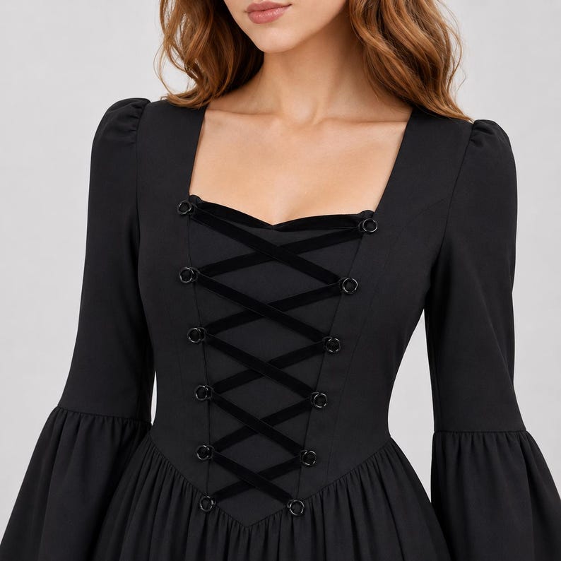 May include: A black long-sleeved dress featuring a square neckline and a central corset-style bodice. The front panel includes black velvet ribbon lacing threaded through circular metal eyelets, complemented by flared sleeves and a fitted waist.