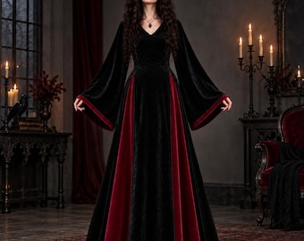 May include: A floor-length velvet dress featuring a black bodice and long flared sleeves with deep red velvet panels integrated into the skirt. The garment has a V-neckline and a fitted waist, showcasing a contrasting color scheme of black and red.