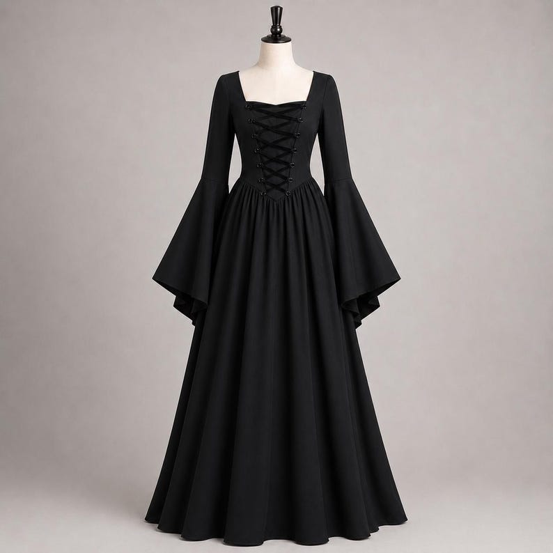 May include: A floor-length black dress featuring long flared sleeves, a square neckline, and a central bodice panel with a black lace-up corset-style closure. The garment has a fitted waist that transitions into a full, flowing skirt.