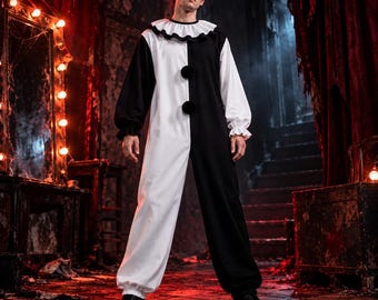 May include: A black and white color-blocked jumpsuit featuring long sleeves with ruffled cuffs, a ruffled collar, and two large black pom-poms on the front. The garment has a loose fit with elasticized leg openings and a simple round neckline.