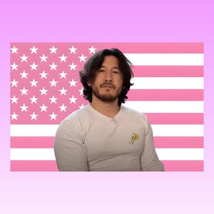 Könnte beinhalten: Eine Person mit dunklem Haar und Bart trägt ein weißes Langarmshirt mit einer kleinen gelben Grafik auf der Brust. Der Hintergrund zeigt eine stilisierte amerikanische Flagge mit horizontalen Streifen und Sternen in Rosa und Weiß.