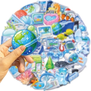 May include: A collection of assorted stickers featuring various blue-toned illustrations including a planet with rings, tropical fish, coral, computers, and household items, arranged in a circular cluster with a glossy finish on each individual piece.