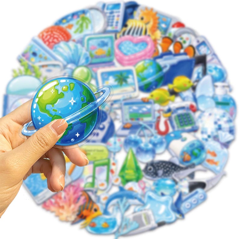 May include: A collection of assorted stickers featuring various blue-toned illustrations including a planet with rings, tropical fish, coral, computers, and household items, arranged in a circular cluster with a glossy finish on each individual piece.