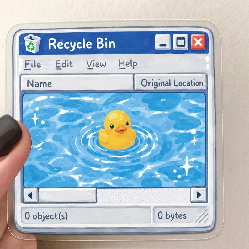 May include: A clear square sticker featuring a computer window labeled Recycle Bin. The interface includes menu options for File, Edit, View, and Help. The main area displays a yellow rubber duck floating in blue water with white sparkles.