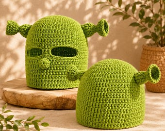 May include: A bright lime green crochet balaclava featuring two protruding trumpet-shaped ears and a central nose detail, accompanied by a matching lime green crochet beanie hat that also features two protruding trumpet-shaped ears.