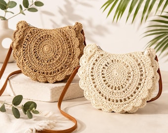 May include: Two half-moon shaped crossbody bags featuring intricate circular crochet patterns with scalloped edges. One bag is a light tan color, and the other is a cream color. Both bags include thin brown shoulder straps and top zippers.
