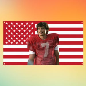 Könnte beinhalten: Ein rechteckiges Wandbanner mit der rot-weiß gestreiften amerikanischen Flagge und einem blauen Feld mit weißen Sternen. In der Mitte befindet sich das Porträt einer Person, die ein rotes Netz-Footballtrikot mit der weißen Nummer 7 trägt.