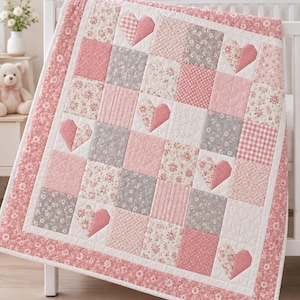Puede incluir: Una colcha de patchwork con una cuadrícula repetitiva de cuadrados en tonos rosa, blanco y gris. El diseño incorpora patrones florales, rayas, cuadros vichy y colores sólidos, con varios cuadrados que presentan aplicaciones de tela en forma de corazón.