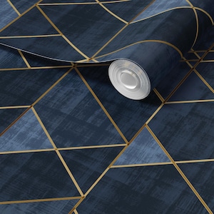 May include: A roll of wallpaper featuring a dark navy blue background with a textured, brushstroke-like finish. The surface is overlaid with a geometric pattern of thin, intersecting gold lines that form various triangles and polygons.