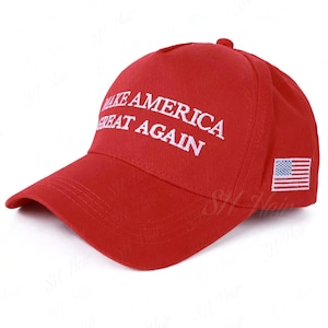 May include: A bright red baseball cap featuring the white embroidered text MAKE AMERICA GREAT AGAIN on the front panel. The side of the cap displays a small, rectangular embroidered patch of the United States flag with red and white stripes.