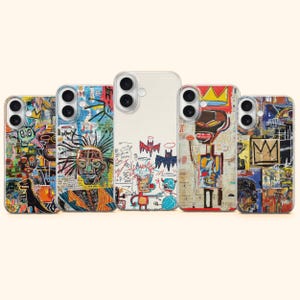 May include: Five smartphone cases arranged in a row, each featuring distinct, colourful, and chaotic neo-expressionist graphic prints. The designs include abstract faces, crowns, bats, and scribbled patterns in vibrant hues of red, blue, yellow, and black.