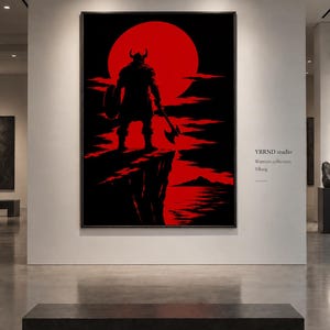 May include: A framed wall art print featuring a black silhouette of a horned warrior holding an axe and shield, standing on a cliff edge against a large red sun. The text YRRND studio, Warriors collection, and Viking is printed on the wall.