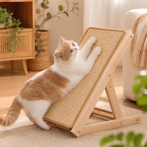 Pode incluir: Um gato de cor clara com manchas laranja estica as patas dianteiras contra um arranhador inclinado. A placa apresenta uma superfície tecida de cor castanha com textura, montada numa estrutura de madeira clara com suporte articulado e parafusos.