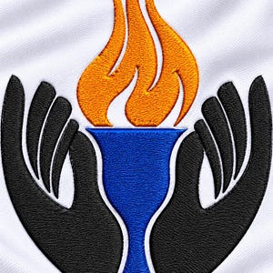 May include: An embroidered patch on a white fabric background featuring a blue chalice centered between two black hands. A vibrant orange flame rises from the top of the chalice, with white outlines defining the shapes of the hands and cup.