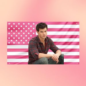 Pode incluir: Um banner de parede retangular com o retrato de uma pessoa de cabelos escuros vestindo uma camisa xadrez vermelha e preta de manga comprida e calça jeans azul, sobre um fundo de bandeira americana rosa e branca com estrelas.