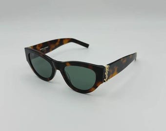 Gafas de sol Saint Laurent SL M94 RIM, estilo ojo de gato con detalles de montura metálica dorada. Unisex.