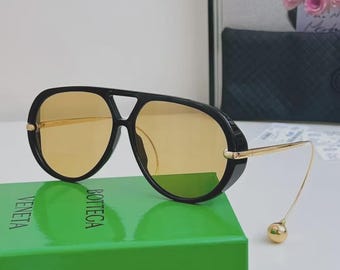 Nuevas gafas de sol unisex Bottega Veneta BV1273, montura negra extragrande y lentes amarillas.