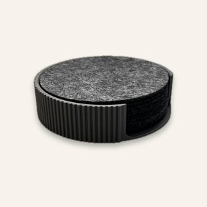 Runder Untersetzerhalter in Schwarz mit einem Stapel Filzuntersetzer in Stone Grey