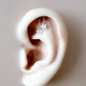 Piercing vertical de hélix con pasador de presión y base plana, estilo industrial, en titanio, con cristal Dainty Star F136 de 16G y 18G. También disponible en rook vertical oculto.