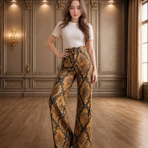 May include: A short-sleeved white crew neck t-shirt paired with high-waisted, wide-leg trousers featuring a brown and black snakeskin print pattern, a matching fabric belt with a rectangular buckle, and a full-length silhouette.