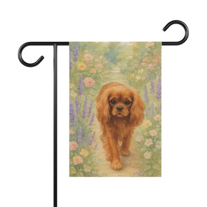 May include: A rectangular garden flag featuring a watercolor illustration of a brown Cavalier King Charles Spaniel walking along a path surrounded by soft-toned pink roses and tall purple lavender flowers, suspended from a black metal stand.