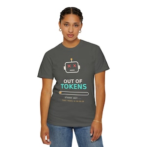 Puede incluir: Una camiseta gris oscuro con un icono de cabeza de robot blanco con ojos en forma de X rojos, el texto "OUT OF TOKENS" en blanco y turquesa, una barra de carga y el texto "please wait..." seguido de "limit resets in 04:59:59".