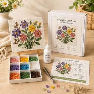 May include: A mosaic art kit featuring a flower bouquet design, including a white box labelled MOSAIC ART KIT FLOWER BOUQUET, a finished mosaic board on a wooden easel, a white tray with colourful tiles, craft adhesive, and a step-by-step guide.