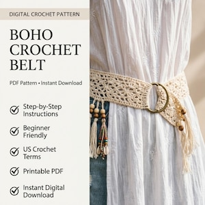 May include: A cream-colored crochet belt featuring an intricate openwork pattern, a large circular brass-toned buckle, and dangling fringe accents adorned with wooden beads and small white seashells, worn over a white dress and blue denim jeans.