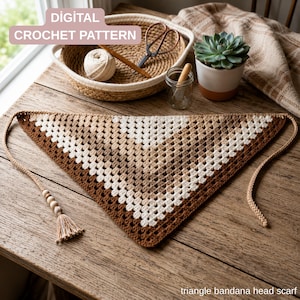 Puede incluir: Un pañuelo bandana triangular con un patrón de ganchillo granny stitch en un degradado de hilos marrón, beige y crema. El pañuelo incluye lazos trenzados con cuentas de madera y una borla. El texto en la imagen dice: DIGITAL CROCHET PATTERN.