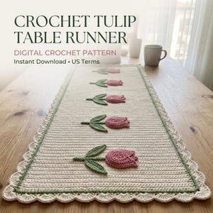 Könnte beinhalten: Ein rechteckiger, cremefarbener Häkel-Tischläufer mit fünf rosa Tulpenmotiven, grünen Stielen und Blättern in einer Reihe. Der Läufer hat einen gewellten Rand, der von einer dünnen grünen Linie umrahmt ist. Text: CROCHET TULIP TABLE RUNNER.
