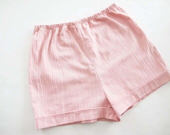 Puede incluir: Pantalones cortos de color rosa claro con cintura elástica. Los pantalones cortos están hechos de una tela texturizada y tienen un ajuste relajado. El dobladillo está doblado. Adecuado para ropa casual.