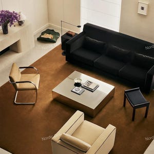 Peut inclure: Un agencement de salon comprenant un grand canapé noir, une table basse carrée métallique, un fauteuil beige avec des accoudoirs chromés, un fauteuil rembourré beige assorti et un petit tabouret noir, le tout sur un grand tapis marron.