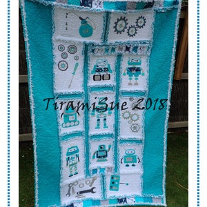 May include: A turquoise and white patchwork quilt with a robot theme. The quilt features various robot designs, gears, spanners, and the text "Tiramisu 2018".