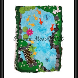 Könnte beinhalten: Ein gerahmtes Textilkunstwerk, das eine Teichszene darstellt. Der Teich zeigt orange und gelbe Koi-Karpfen, eine rosa Seerose und eine Libelle. Eine kleine Holzbrücke überquert das Wasser, umgeben von grünem Laub und Felsen. Der Name des Künstlers und das Jahr sind sichtbar.