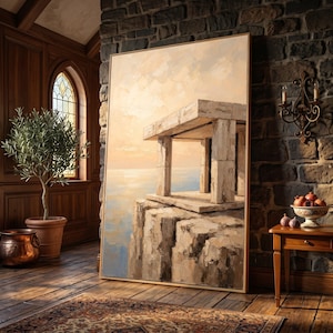 May include: A large rectangular framed oil painting depicting a stone structure on a cliff overlooking a calm sea at sunset. The artwork features textured brushstrokes in shades of beige, cream, and soft blue, capturing a serene coastal landscape.