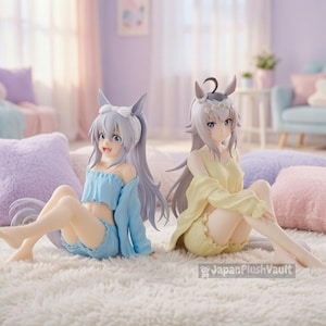 Peut inclure: Deux figurines de style anime avec des oreilles d'animal assises sur un tapis blanc. La figurine de gauche porte un ensemble deux pièces bleu clair à volants et un bandeau blanc. Celle de droite porte un ensemble jaune pâle. Texte : JapanPlushVault.