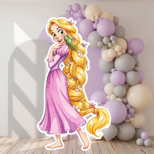 Pode incluir: Um recorte de papelão de uma personagem de desenho animado com longos cabelos loiros trançados, vestindo um vestido roxo com mangas cor-de-rosa e um pequeno camaleão verde no ombro. A personagem está descalça e tem pequenas flores no cabelo.