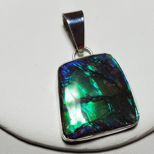 Green blue ammolite pendant.  Set in tarnish resistant silver. Ammonite is seventy one million years old. Necklace of silver and ammolite.