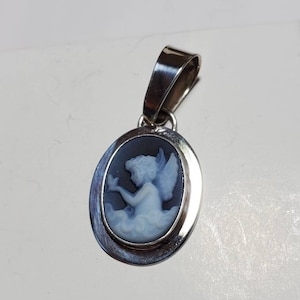 Cameo pendant with Cherub and bird.  Black agate carved in Germany by master stone carvers.  Tarnish resistant silver. Beautiful piece.