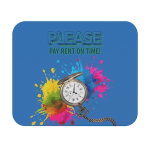 Pode incluir: Um tapete de rato retangular com fundo azul, um design de salpicos de tinta coloridos, um relógio de bolso prateado com corrente e o texto PLEASE PAY RENT ON TIME em letras a negrito azul-escuras e verdes no topo.