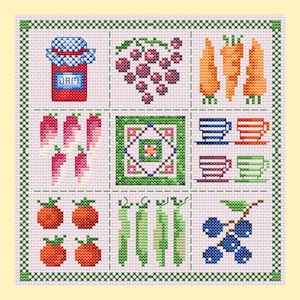 May include: A cross-stitch sampler featuring a grid of nine squares. Designs include a red jar labeled JAM, purple grapes, orange carrots, pink chili peppers, a central geometric floral pattern, four colored teacups, orange tomatoes, green pea pods, and blue berries.