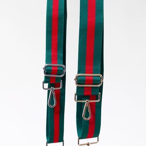 May include: Two adjustable bag straps made of green woven fabric with a central red stripe. Each strap features silver-toned metal hardware, including sliding buckles for length adjustment and swivel lobster claw clasps at both ends for attachment.