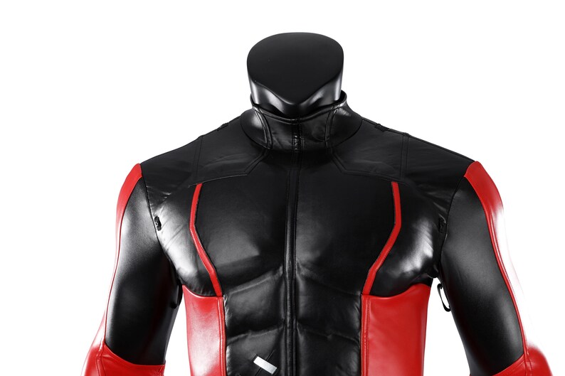 Pu&ograve; includere: Una giacca nera e rossa con colletto alto e chiusura frontale a zip. Il capo presenta un design strutturato con pannelli neri sul petto e sulle spalle, accentuati da vivaci strisce verticali rosse lungo i lati e le maniche.