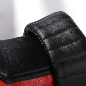 Pu&ograve; includere: Un guantone da boxe con un corpo principale rosso vivace e un polsino nero a contrasto. Il polsino presenta cuciture trapuntate orizzontali, mentre la sezione principale ha un pannello nero liscio integrato sulla superficie rossa.