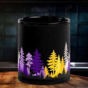May include: A black ceramic mug featuring a wrap-around graphic of a forest silhouette at the base. The trees are rendered in vibrant shades of purple, yellow, and white, creating a stark contrast against the solid black background of the mug.