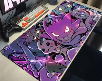 May include: A rectangular desk mat featuring a vibrant, multi-layered graphic print of various purple and dark-toned ghost-type creatures. The design includes a prominent central character with a wide grin, surrounded by smaller figures in shades of violet, indigo, and black, creating a dense, stylized collage across the entire surface.