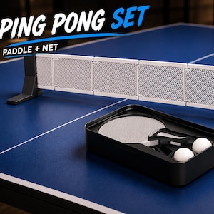 Puede incluir: Un set de ping pong que incluye una red retráctil blanca con soportes negros y un estuche de almacenamiento negro con una pala y dos pelotas blancas. El texto PING PONG SET PADDLE + NET es visible en la esquina superior izquierda.