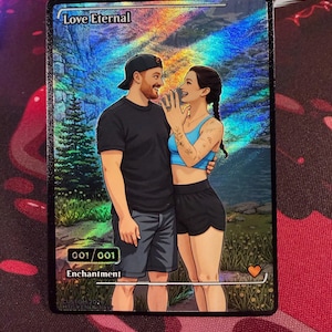Op de afbeelding: Een rechthoekige holografische verzamelkaart getiteld Love Eternal met een illustratie van twee personen die samen in een boslandschap staan. De kaart toont de tekst 001/001, Enchantment en een klein oranje hartpictogram in de hoek.