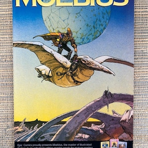 May include: A comic book cover titled MOEBIUS featuring a figure riding a large winged creature above a landscape with giant bones. The text reads BEYOND COMICS. BEYOND FICTION. BEYOND IMAGINATION. and includes a small display of six other book covers.