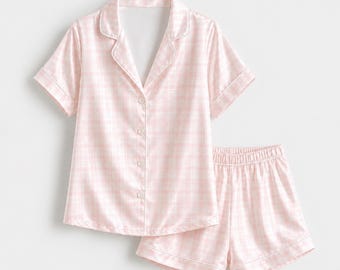 Conjunto de pijama clásico a juego de satén con botones y estampado de cuadros vichy rosa y blanco.